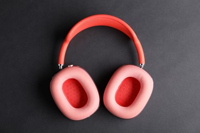 Photo of Pair of stylish pink headphones on black background, top view
