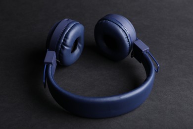 Photo of Pair of stylish blue headphones on black background