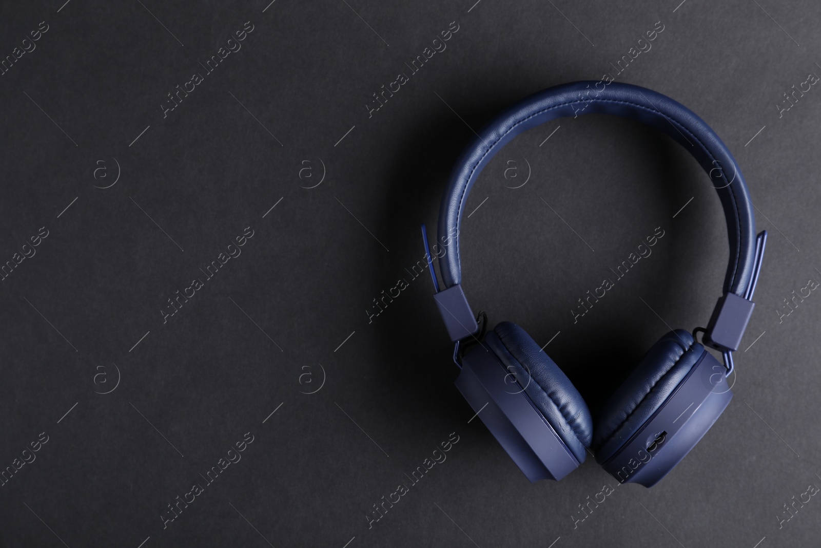Pair of stylish blue headphones on black background, top view. Space for text Photo of Pair of stylish blue headphones on black background, top view. Space for text