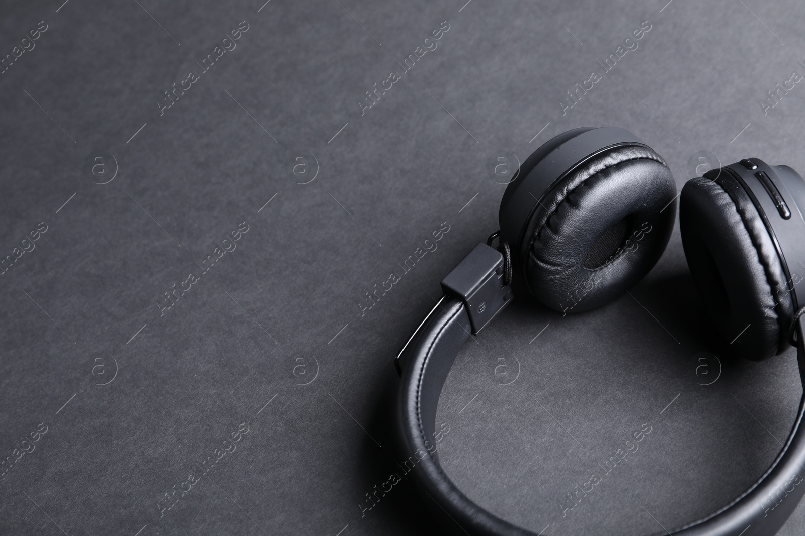 Pair of stylish headphones on black background, closeup. Space for text Photo of Pair of stylish headphones on black background, closeup. Space for text