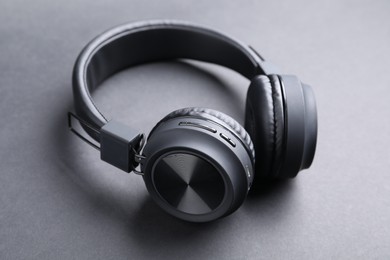 Photo of Pair of stylish headphones on black background, closeup