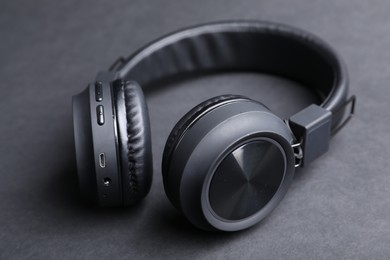 Photo of Pair of stylish headphones on black background, closeup