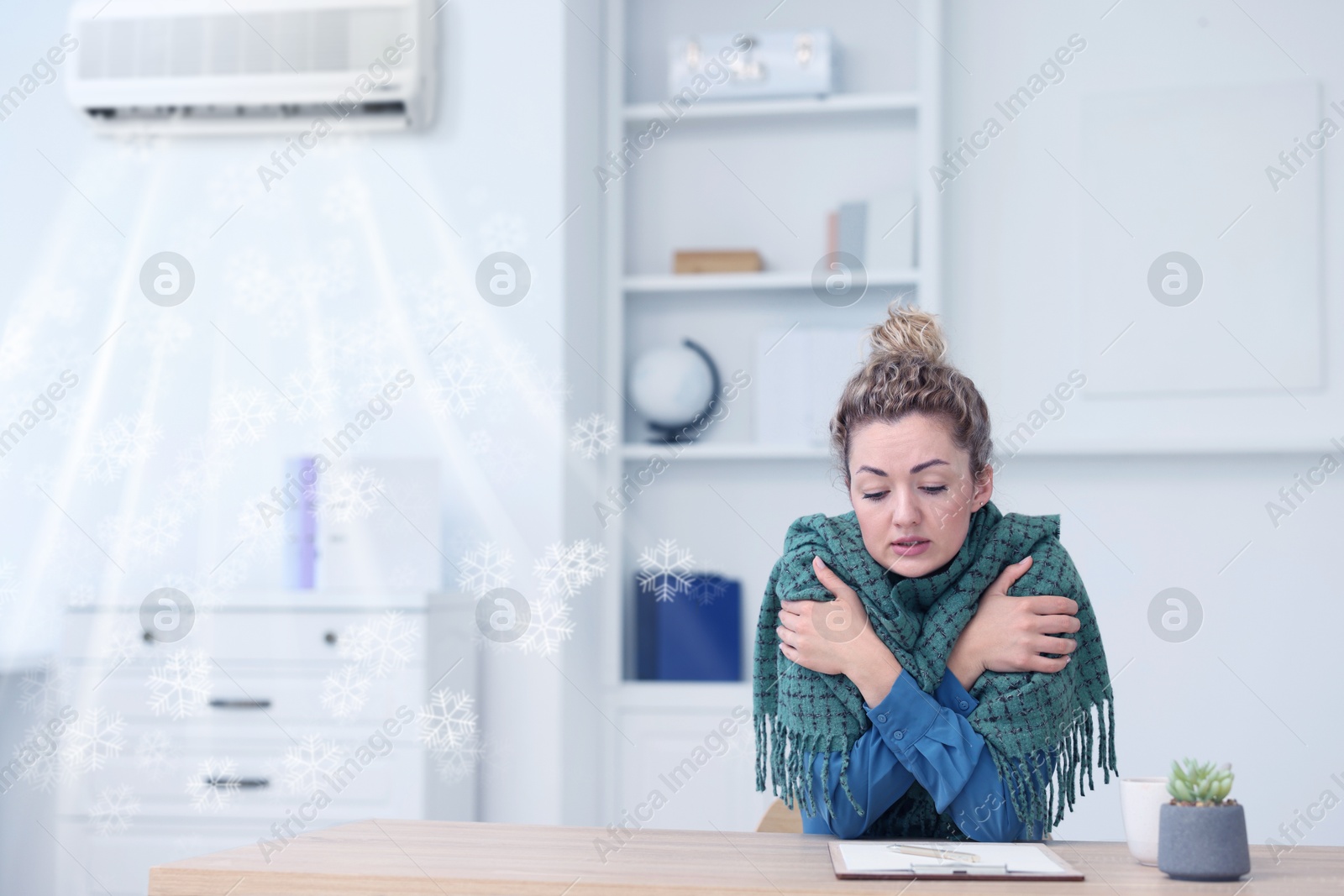 Broken air conditioner or temperature set too low. Woman with scarf freezing at workplace in office Image of Broken air conditioner or temperature set too low. Woman with scarf freezing at workplace in office