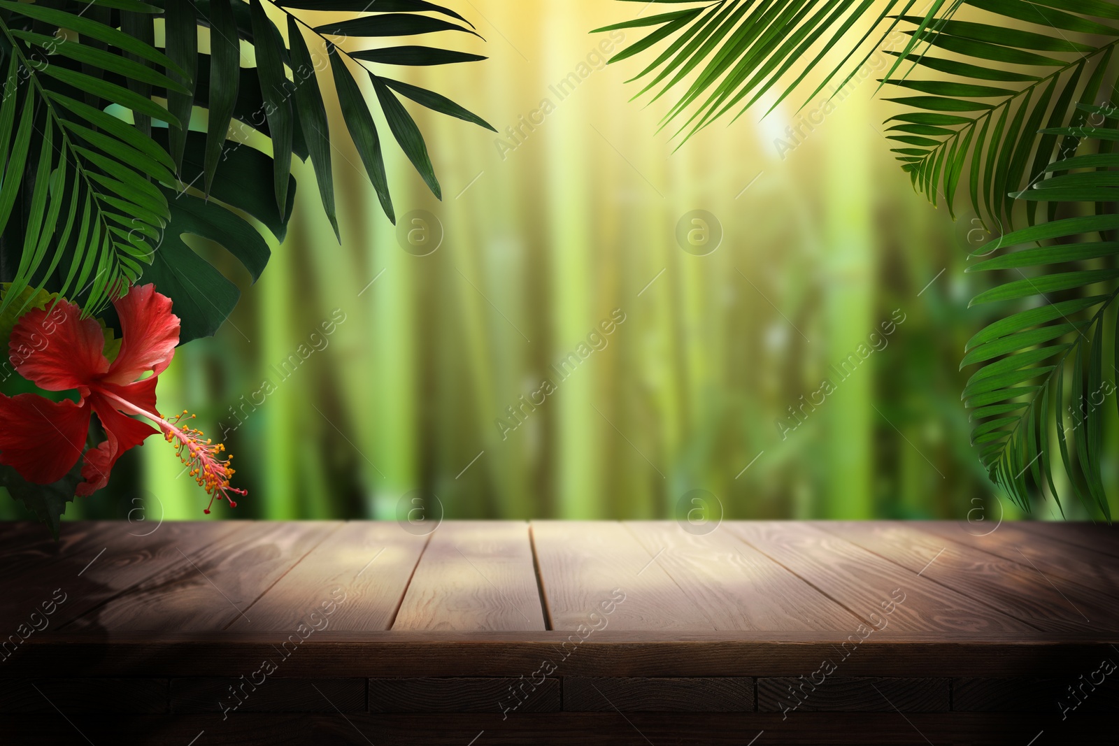Image of Wooden table in jungle. Tropical leaves and flower above empty surface. Poster with space for design