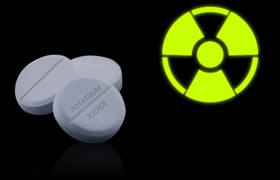 Image of Potassium iodide pills and warning sign on black background. Iodine consumption during radioactive contamination