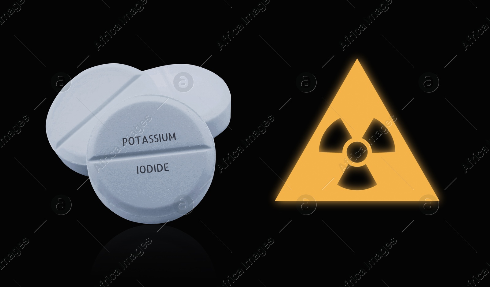 Potassium iodide pills and warning sign on black background. Iodine consumption during radioactive contamination Image of Potassium iodide pills and warning sign on black background. Iodine consumption during radioactive contamination