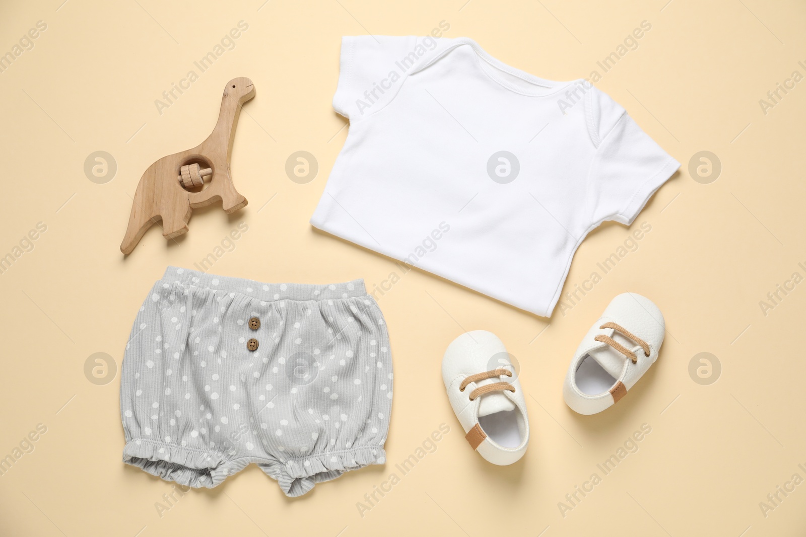 Stylish baby clothes, shoes and accessory on beige background, flat lay Photo of Stylish baby clothes, shoes and accessory on beige background, flat lay