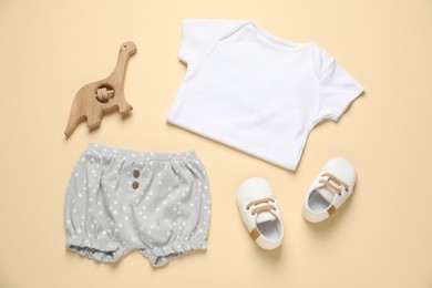 Photo of Stylish baby clothes, shoes and accessory on beige background, flat lay