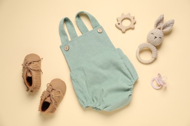 Photo of Stylish baby clothes and accessories on beige background, flat lay