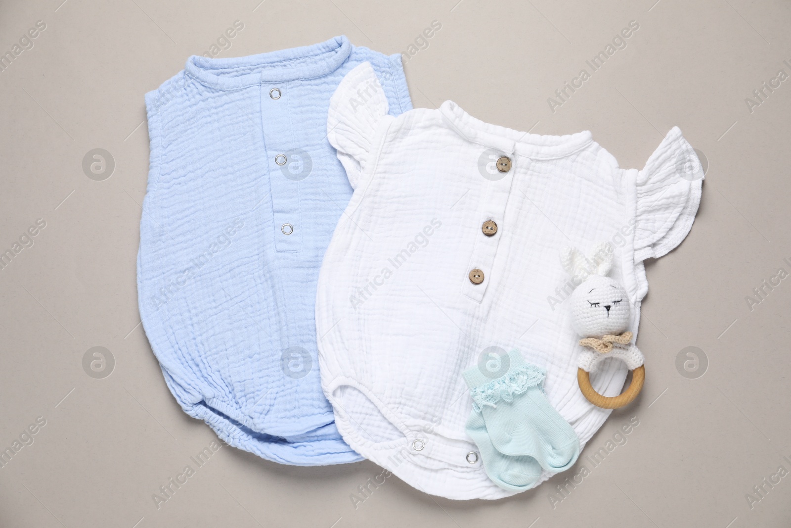 Stylish baby clothes and accessory on grey background, flat lay Photo of Stylish baby clothes and accessory on grey background, flat lay
