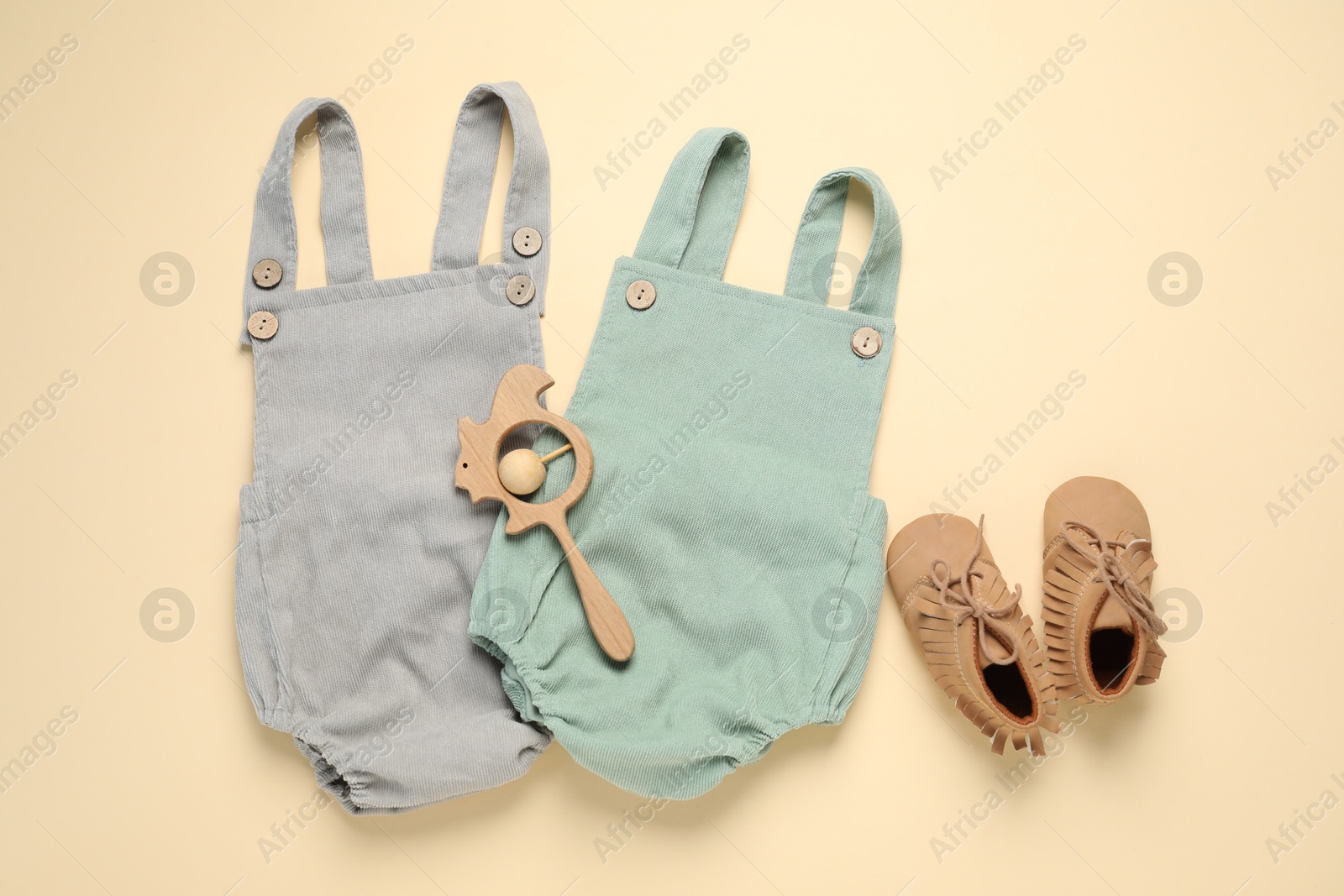 Stylish baby clothes, shoes and accessory on beige background, flat lay Photo of Stylish baby clothes, shoes and accessory on beige background, flat lay