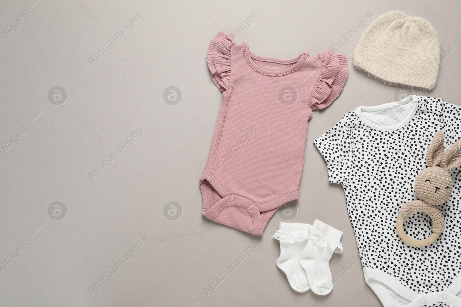 Stylish baby clothes and accessories on grey background, flat lay. Space for text Photo of Stylish baby clothes and accessories on grey background, flat lay. Space for text