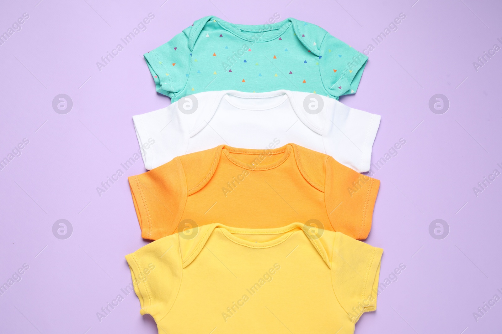 Photo of Stylish baby clothes on violet background, flat lay