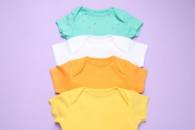 Photo of Stylish baby clothes on violet background, flat lay