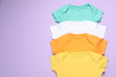 Photo of Stylish baby clothes on violet background, flat lay. Space for text