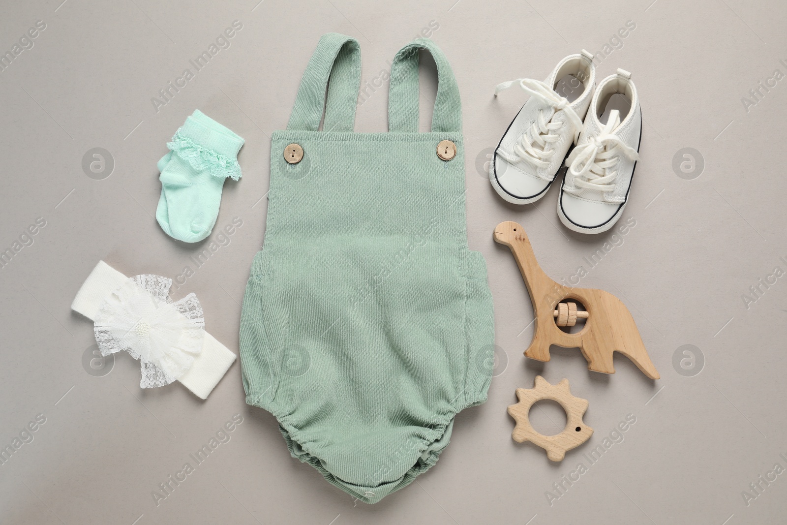 Stylish baby clothes and accessories on grey background, flat lay Photo of Stylish baby clothes and accessories on grey background, flat lay