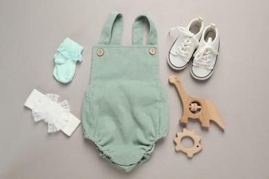 Photo of Stylish baby clothes and accessories on grey background, flat lay