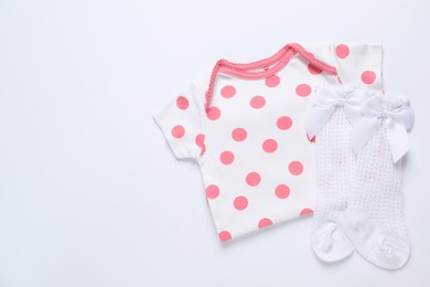 Photo of Stylish baby onesie and socks on white background, flat lay. Space for text