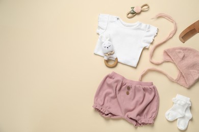 Photo of Stylish baby clothes and accessories on beige background, flat lay. Space for text