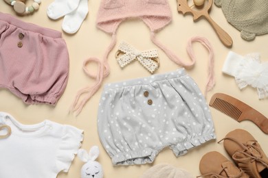 Photo of Stylish baby clothes and accessories on beige background, flat lay