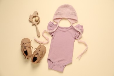 Photo of Stylish baby clothes and accessories on beige background, flat lay