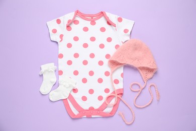 Photo of Stylish baby onesie and accessories on violet background, flat lay