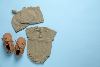 Photo of Stylish baby clothes and accessories on light blue background, flat lay. Space for text