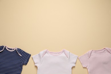 Photo of Stylish baby clothes on beige background, flat lay. Space for text