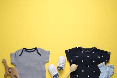 Photo of Stylish baby clothes and accessories on yellow background, flat lay. Space for text