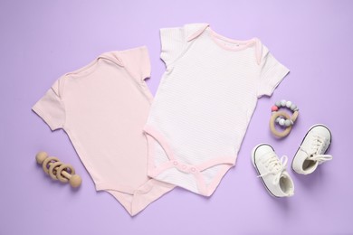 Photo of Stylish baby onesies and accessories on violet background, flat lay