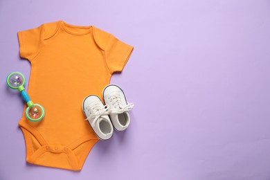 Photo of Stylish baby clothes and accessory on violet background, flat lay. Space for text