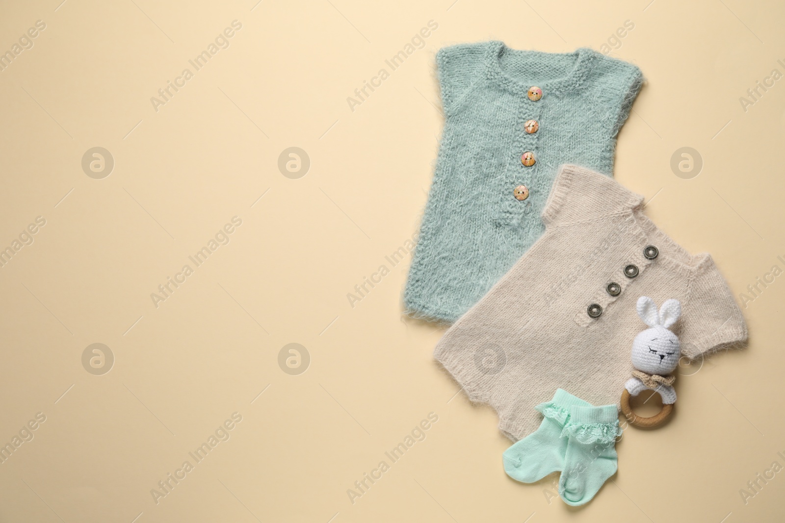 Stylish baby clothes and accessories on beige background, flat lay. Space for text Photo of Stylish baby clothes and accessories on beige background, flat lay. Space for text