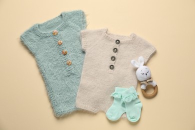 Photo of Stylish baby clothes and accessories on beige background, flat lay