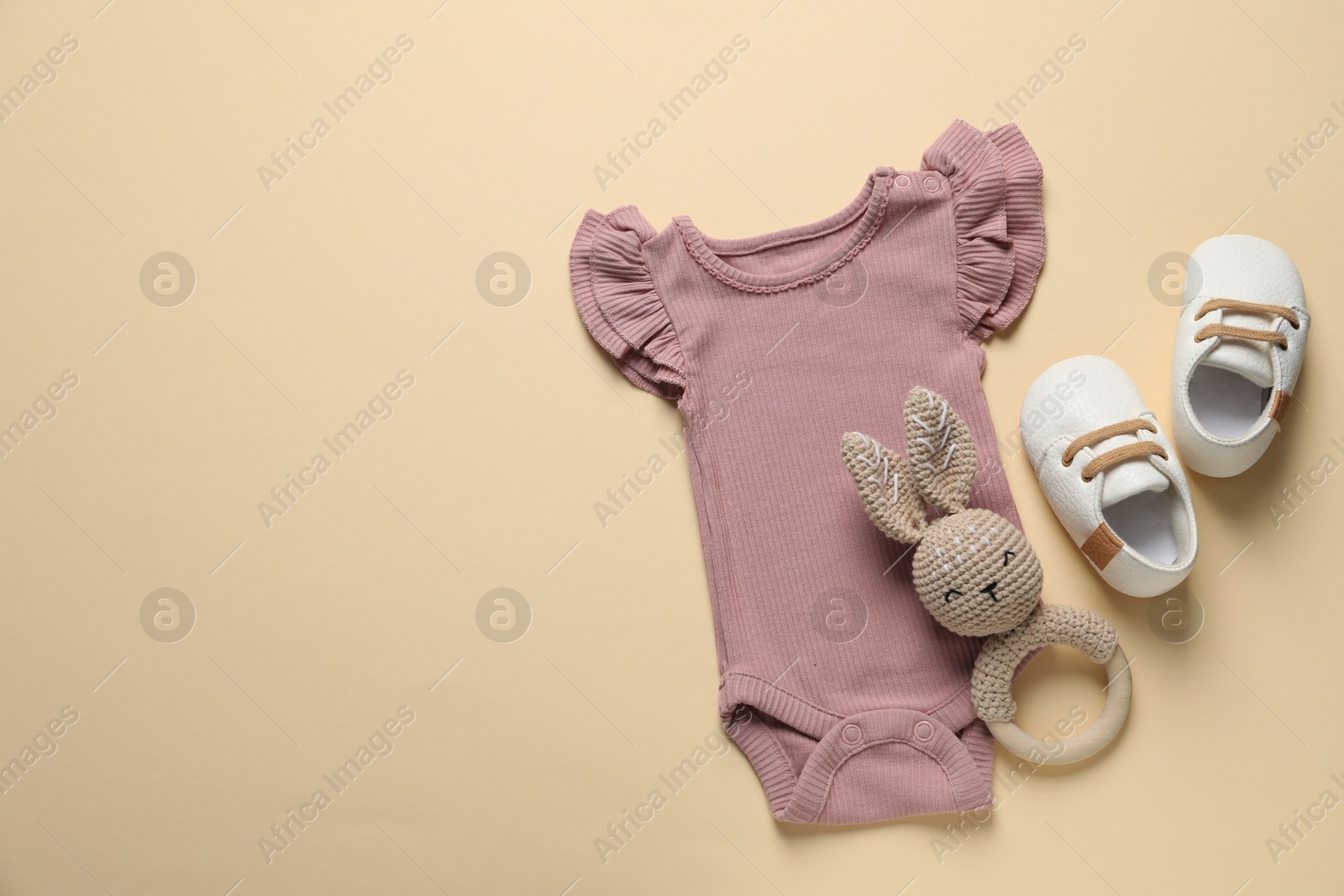 Stylish baby clothes and accessories on beige background, flat lay. Space for text Photo of Stylish baby clothes and accessories on beige background, flat lay. Space for text