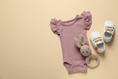 Photo of Stylish baby clothes and accessories on beige background, flat lay. Space for text
