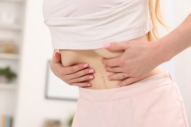 Photo of Woman doing abdominal vacuum exercise at home, closeup