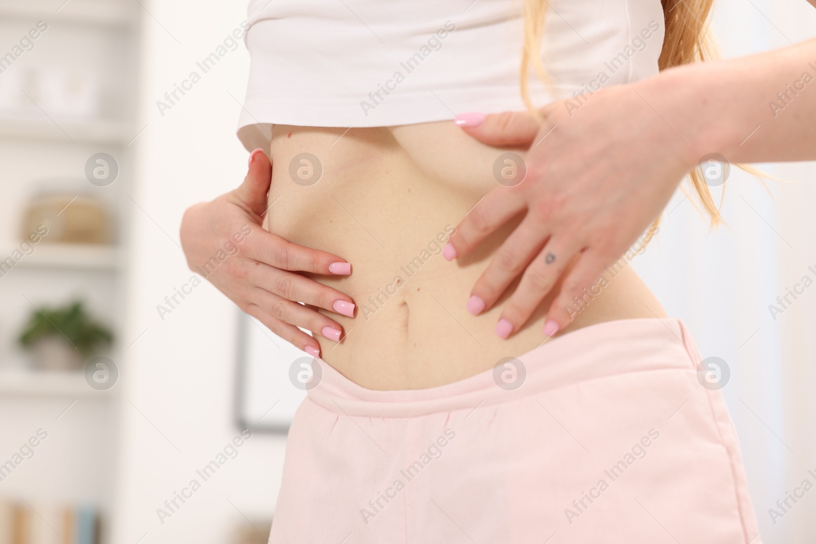 Woman doing abdominal vacuum exercise at home, closeup Photo of Woman doing abdominal vacuum exercise at home, closeup