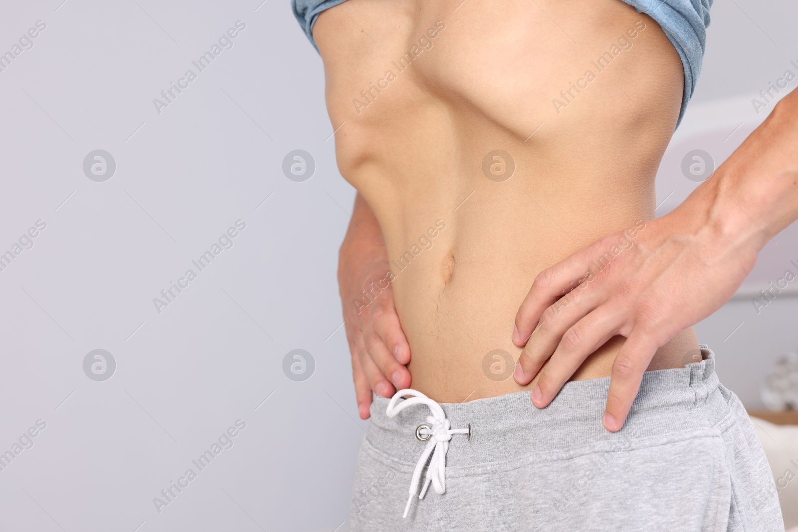 Man doing abdominal vacuum exercise at home, closeup. Space for text Photo of Man doing abdominal vacuum exercise at home, closeup. Space for text