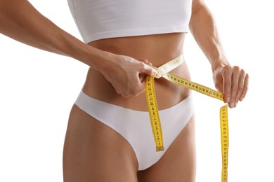 Photo of Woman measuring her belly with tape on white background, closeup