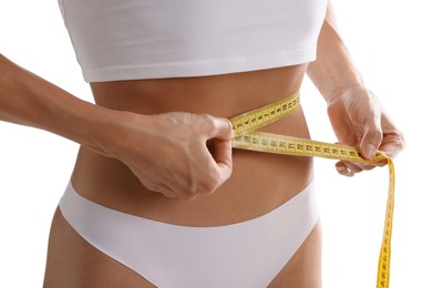 Photo of Woman measuring her belly with tape on white background, closeup