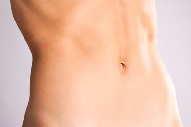 Photo of Woman with flat belly on grey background, closeup