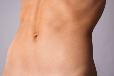 Photo of Woman with flat belly on grey background, closeup