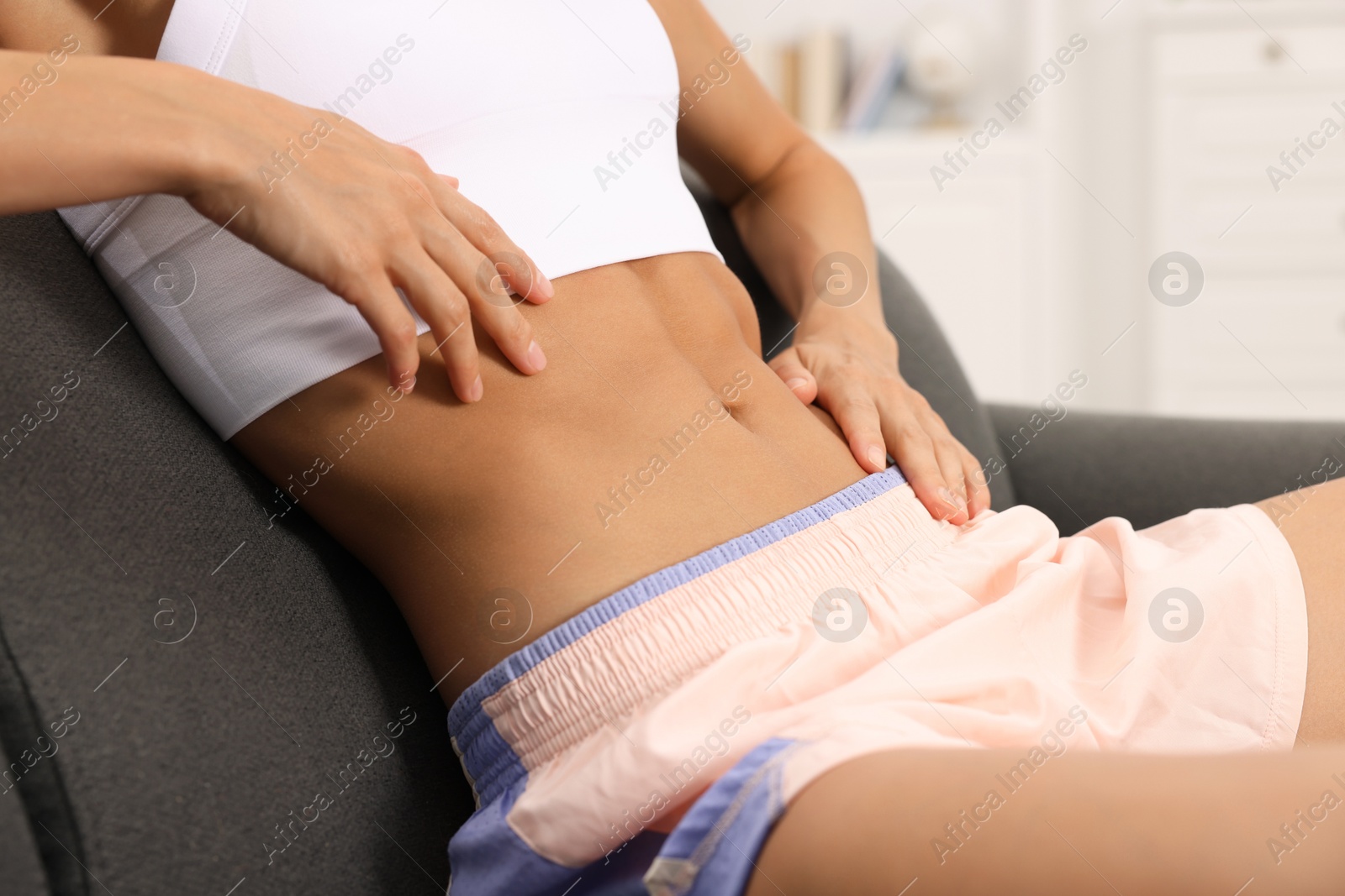 Woman with flat belly on sofa at home, closeup Photo of Woman with flat belly on sofa at home, closeup