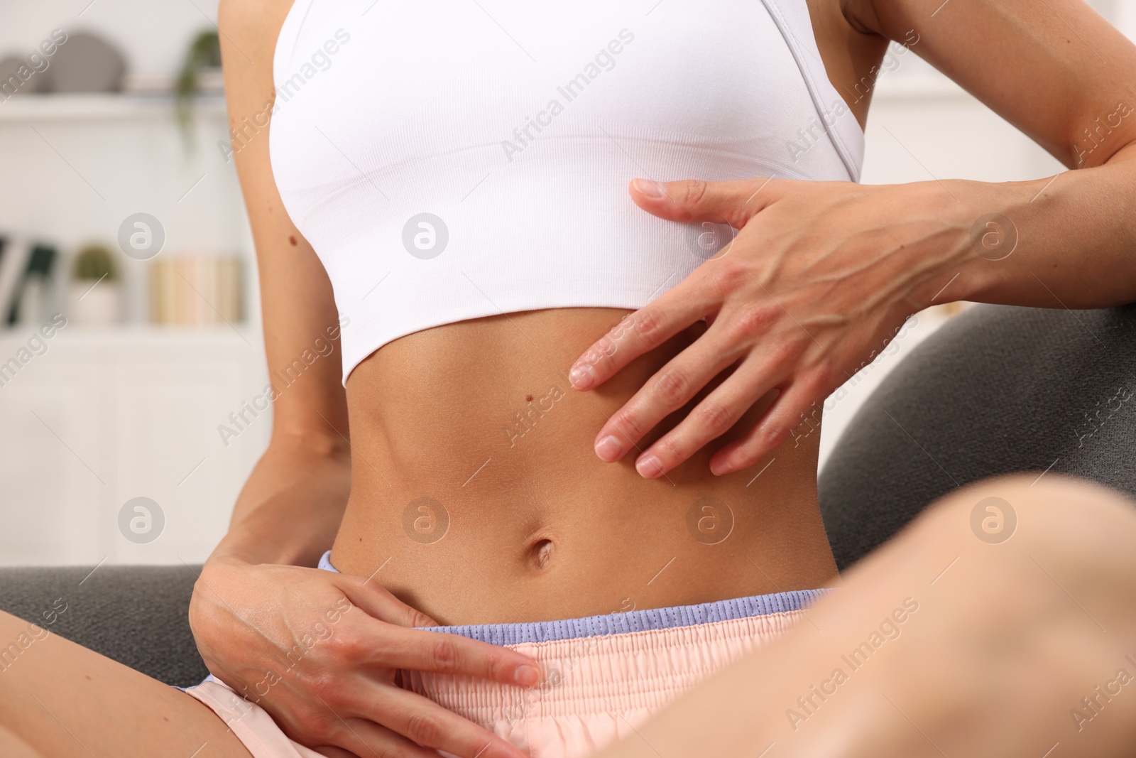 Woman with flat belly on sofa at home, closeup Photo of Woman with flat belly on sofa at home, closeup