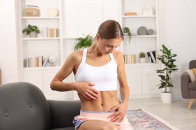 Photo of Woman with flat belly on sofa at home