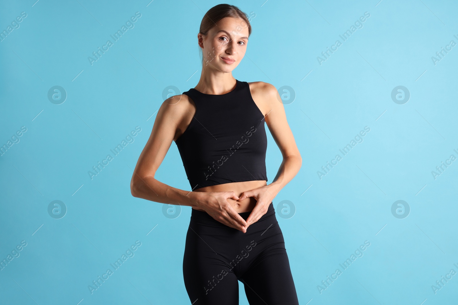 Photo of Woman with flat belly on light blue background