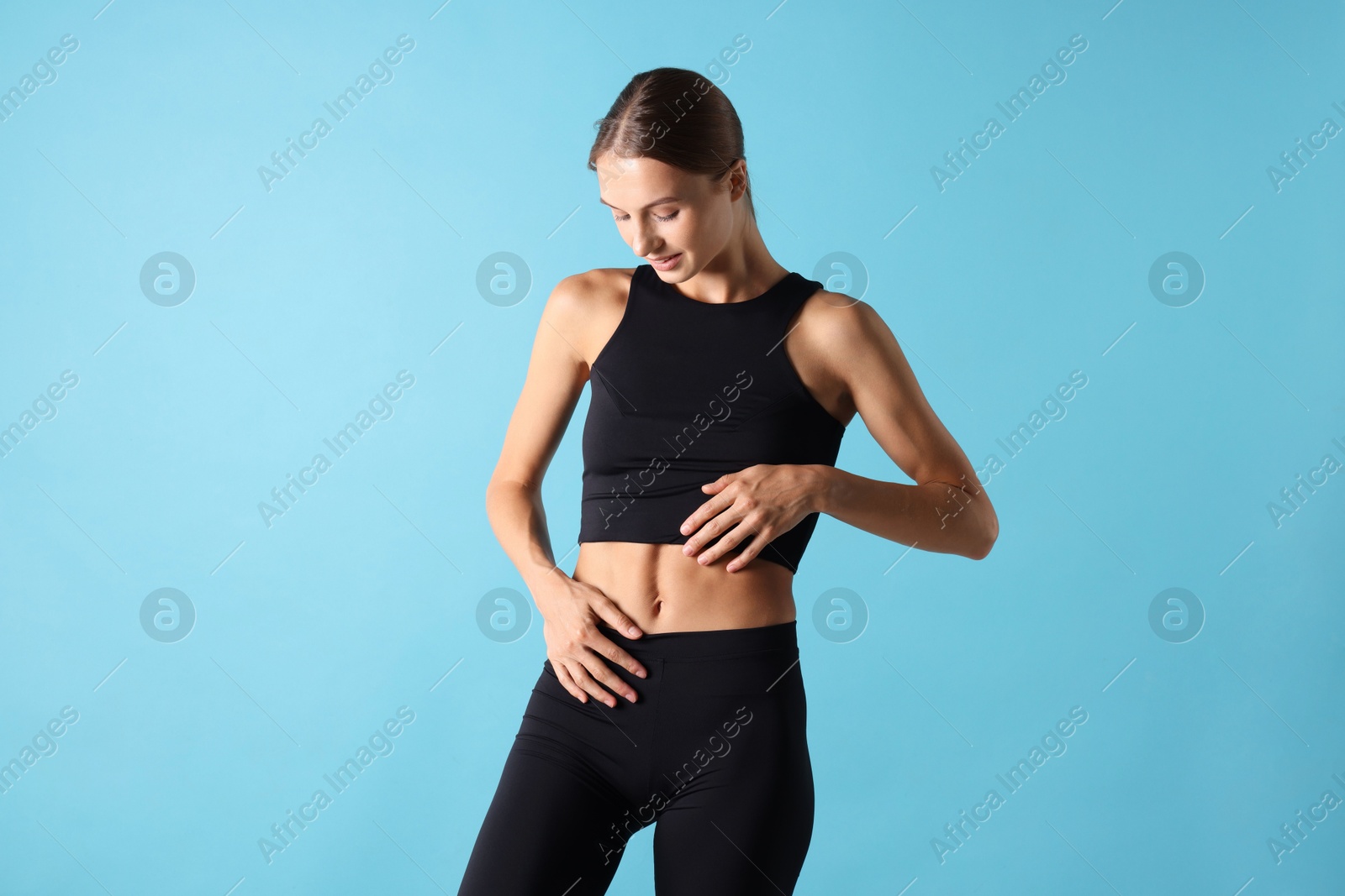 Photo of Woman with flat belly on light blue background