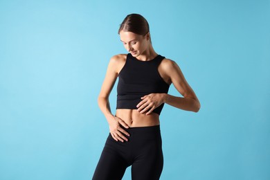 Photo of Woman with flat belly on light blue background