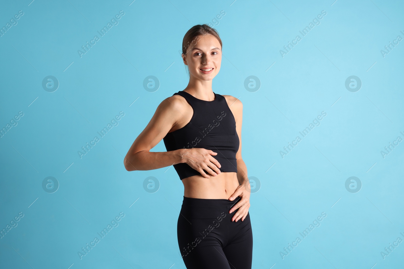 Photo of Woman with flat belly on light blue background