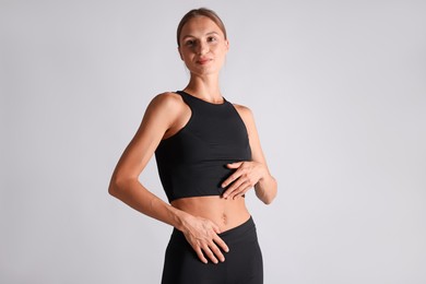 Photo of Woman with flat belly on light grey background